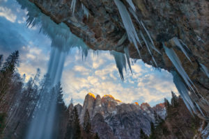 San Lucano valley in Agordino, the waterfall 'dell'Inferno' in winter with the Agner mountain at sunset, Dolomites, Taibon, Belluno, Italy San Lucano valley in Agordino, the waterfall 'dell'Inferno' in winter with the Agner mountain at sunset, Dolomites, Taibon, Belluno, Italy